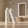 Two bottles of 'Snow Blow Dry' hair product by Vive Hermosa on a leafy ground.